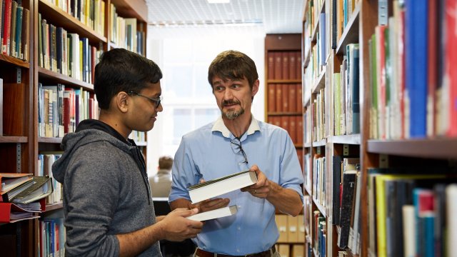 Sidney's librarian assisting a student in the College library